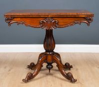 A Victorian rosewood fold over card table with a green baize inset top, turned support and carved