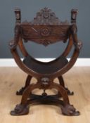 A late 19th century continental Savonarola open armchair with rams mask handles and carved