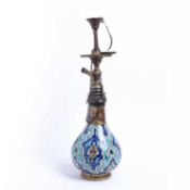 An old Iznik style tin glazed Hookah with pottery base and enamelled engraved brass mounts, possibly