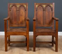 A pair of Gothic style oak open armchairs with panelled backs and seat, each 56cm wide x 42cm deep x