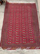 A late 20th century red ground rug 106cm x 155cmCondition report: Needs cleaning, some wear at the