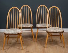 A set of four Ercol light elm spindle back dining chairs Condition report: In good condition