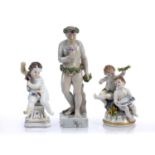 Collection of three continental porcelain figures to include a standing male holding grapes to one