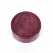 Red lacquered snuff box of circular form, the pull-off cover with a relief of the bust of Louis