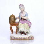 Meissen figure, Touch the lady seated by a table with a parrot crossed swords in blue and incised