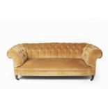 Large button upholstered Chesterfield on mahogany supports with brass castors, 198cm wide, 96cm