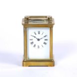 An early 20th century French brass carriage timepiece with white enamel dial, the plain case with