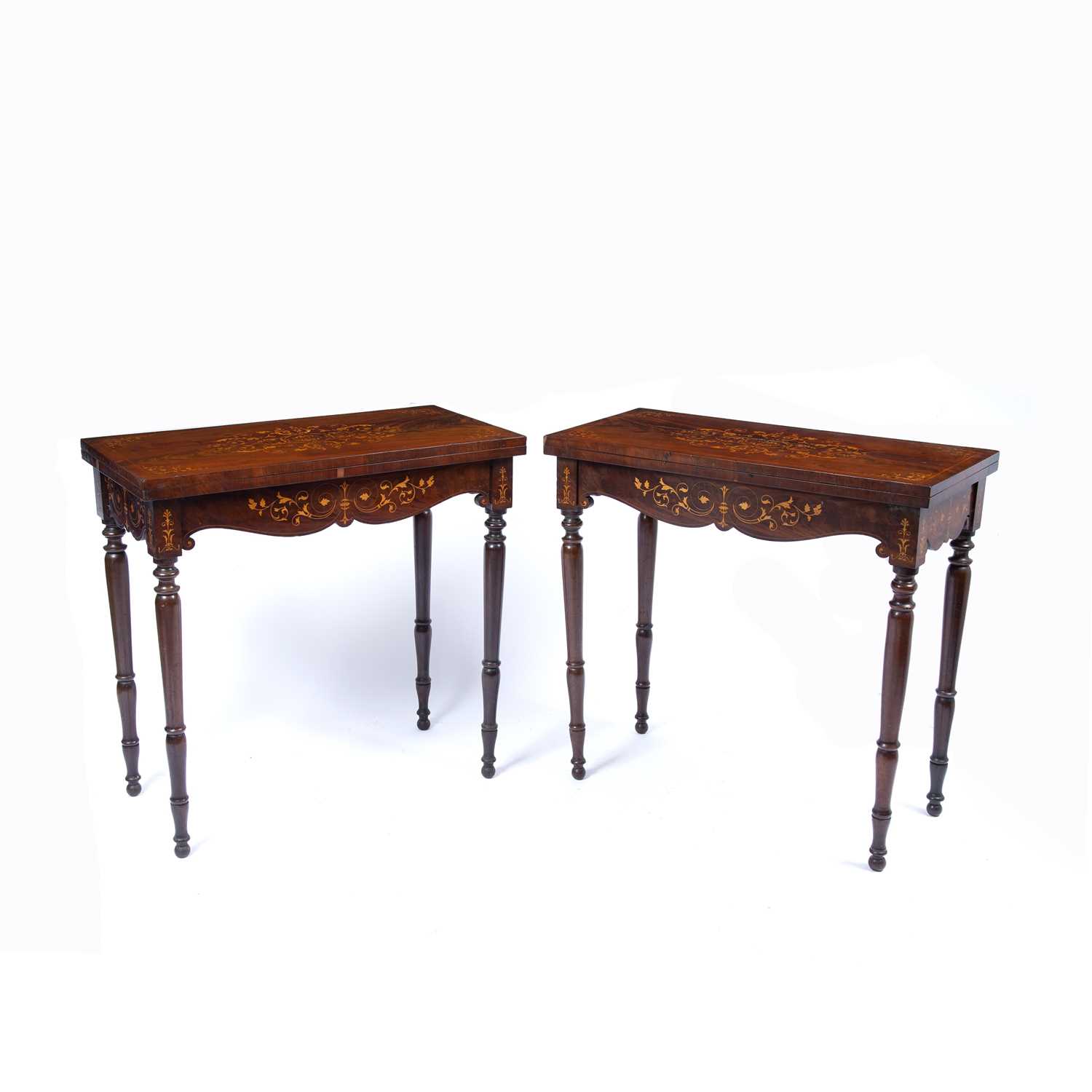 A pair of Victorian mahogany fold over top card tables, the tops inlaid with scrolling and flowering