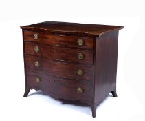 A George III serpentine fronted mahogany chest, the top with a narrow crossband above four graduated