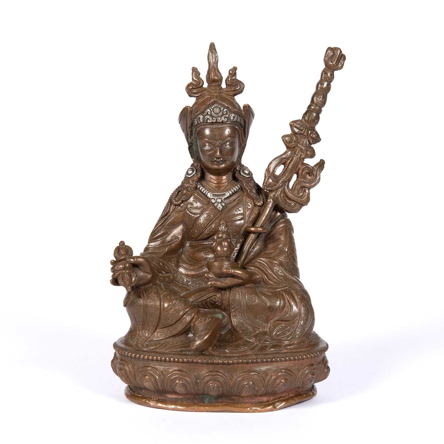 A 19th Century Tibetan seated Buddha, cast copper with engraved decoration, the Buddha holding a