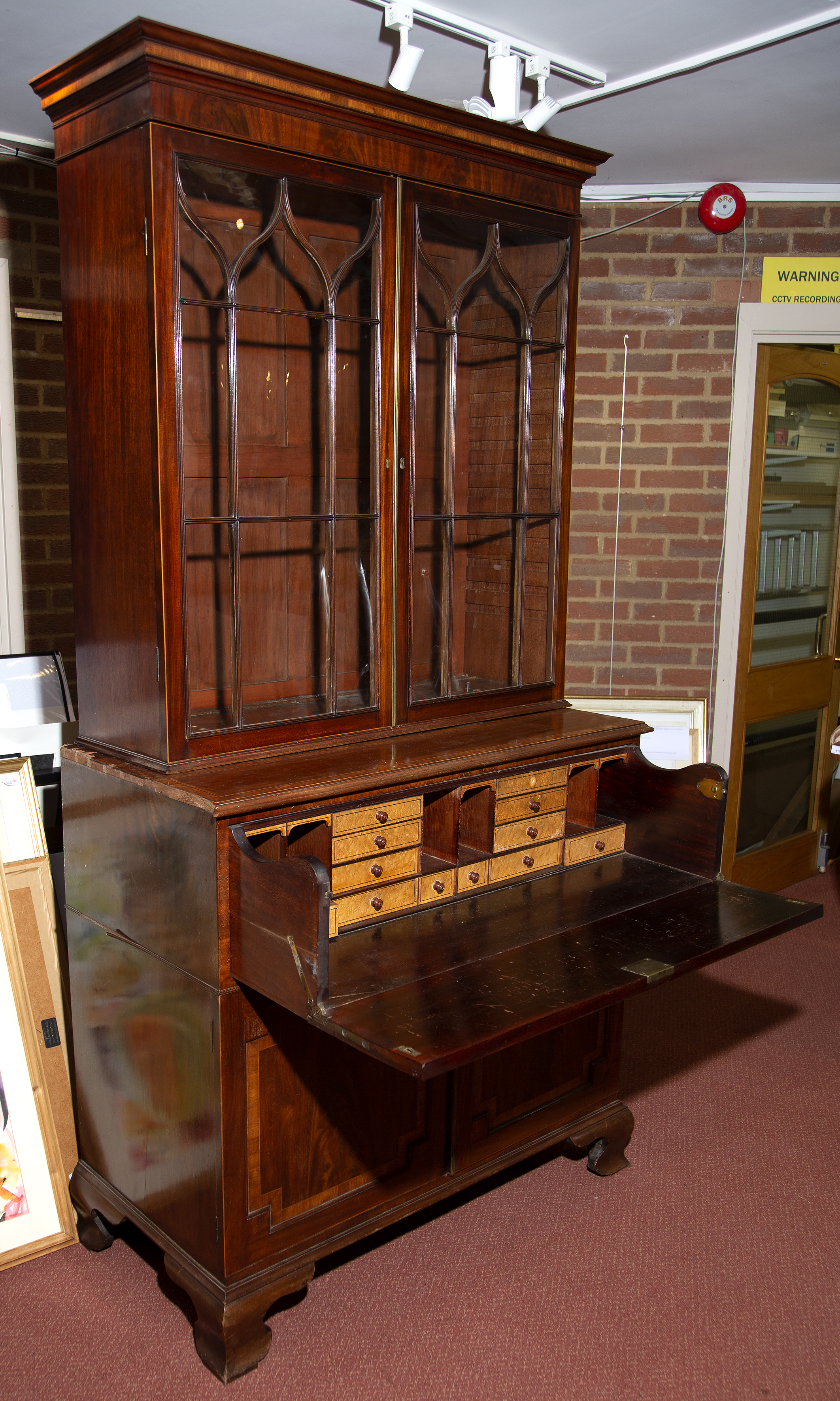 A George III mahogany, crossbanded and inlaid secretaire bookcase, raised on bracket feet, 110cm x