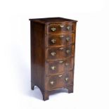 An old reproduction serpentine pillar chest of five long drawers with brass handles, bracket feet