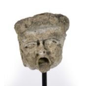 An English Medieval Stone Grotesque Fragmentary head, carved weathered limestone mounted on a