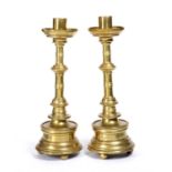 A pair of 16th Century German or south Netherlandish brass candlesticks, turned columns on ball feet