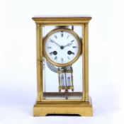 A late 19th century brass four glass mantel clock, with circular white enamel dial, the movement