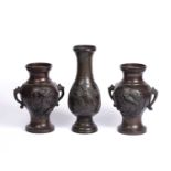 A pair of Japanese bronze baluster vases with elephant trunk handles and raised bird decoration,