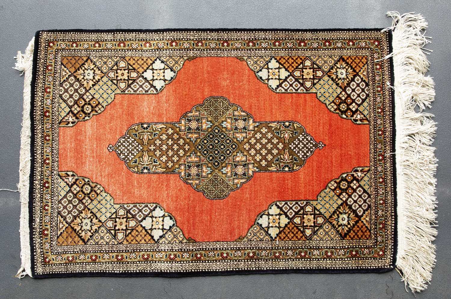 A Persian silk Qum mat with central star shaped medallion on a brick red ground, 84 x 57cm