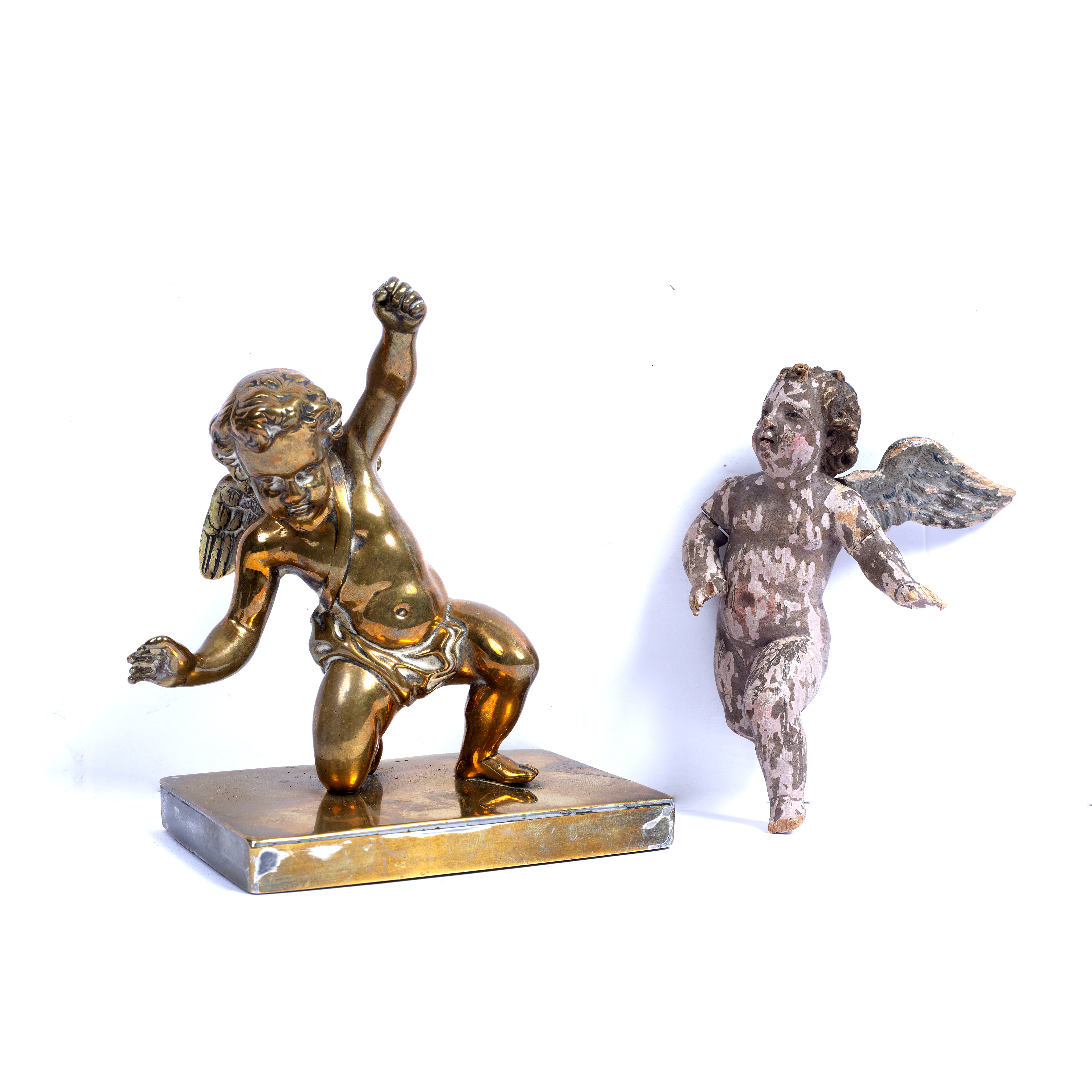 A polished bronze paperweight in the form of a cherub, 13cm high and an antique carved wooden