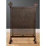 A late 19th century steel arts and crafts fire screen with scrolling finials, mesh panel and on