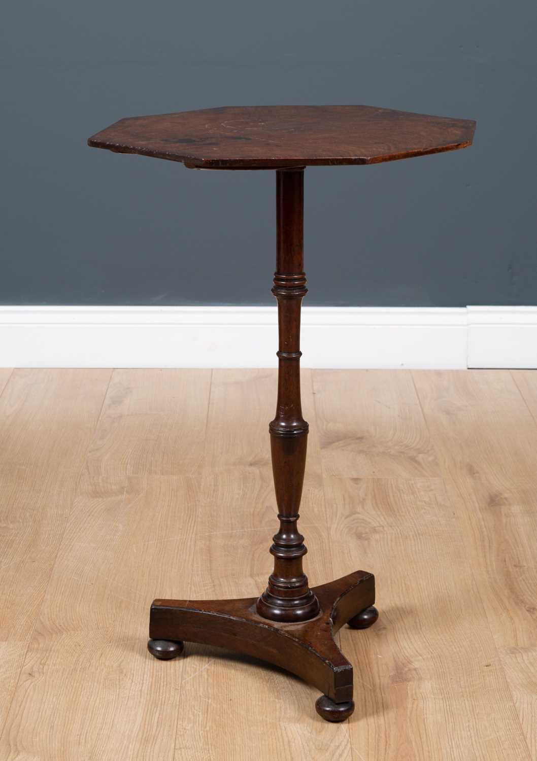 A mahogany occasional table with octagonal top, turned column support, triform base and bun feet,