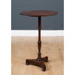 A mahogany occasional table with octagonal top, turned column support, triform base and bun feet,