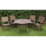 A modern circular teak folding garden table and four matching chairs with armrests, table 100cm