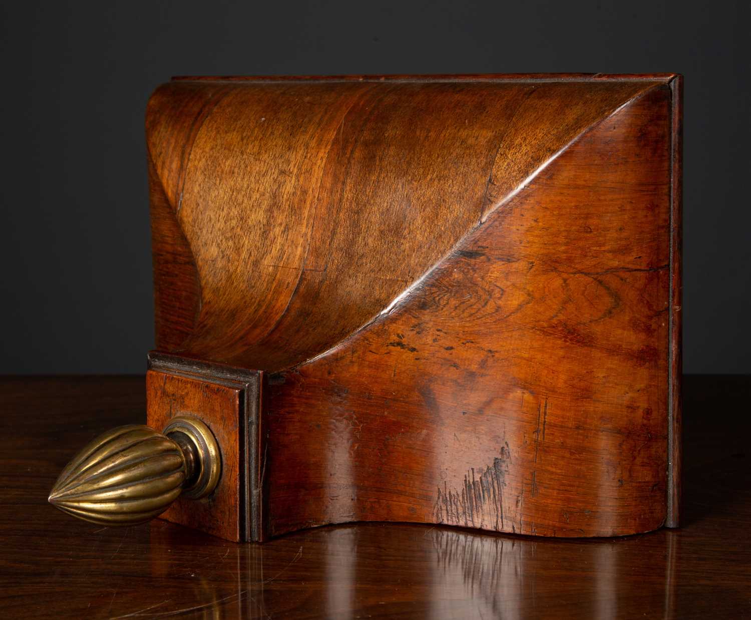 A 19th century walnut clock wall bracket with ogee form with brass finial, 28.5cm wide x 17.5cm deep