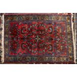 A mid 20th century Middle Eastern red ground rug with stylised foliate decoration, 106cm x 151cm