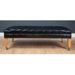 A contemporary rectangular low black leather button upholstered stool with square tapering beechwood