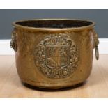 A 19th century brass log bin with embossed decorative panel to the side and lion head ring