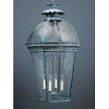 A large copper hall lantern, the cylindrical glass base and dome top within a copper fretwork floral