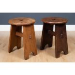 A pair of Art and Crafts style oak low stools, the circular top with carrying handle on two wide
