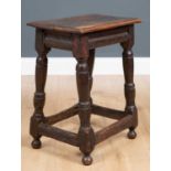 An 18th century and later oak stool with rectangular top and turned legs united by stretchers,