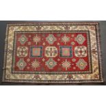A late 20th / early 21st century red and blue ground rug with a banded border and geometric