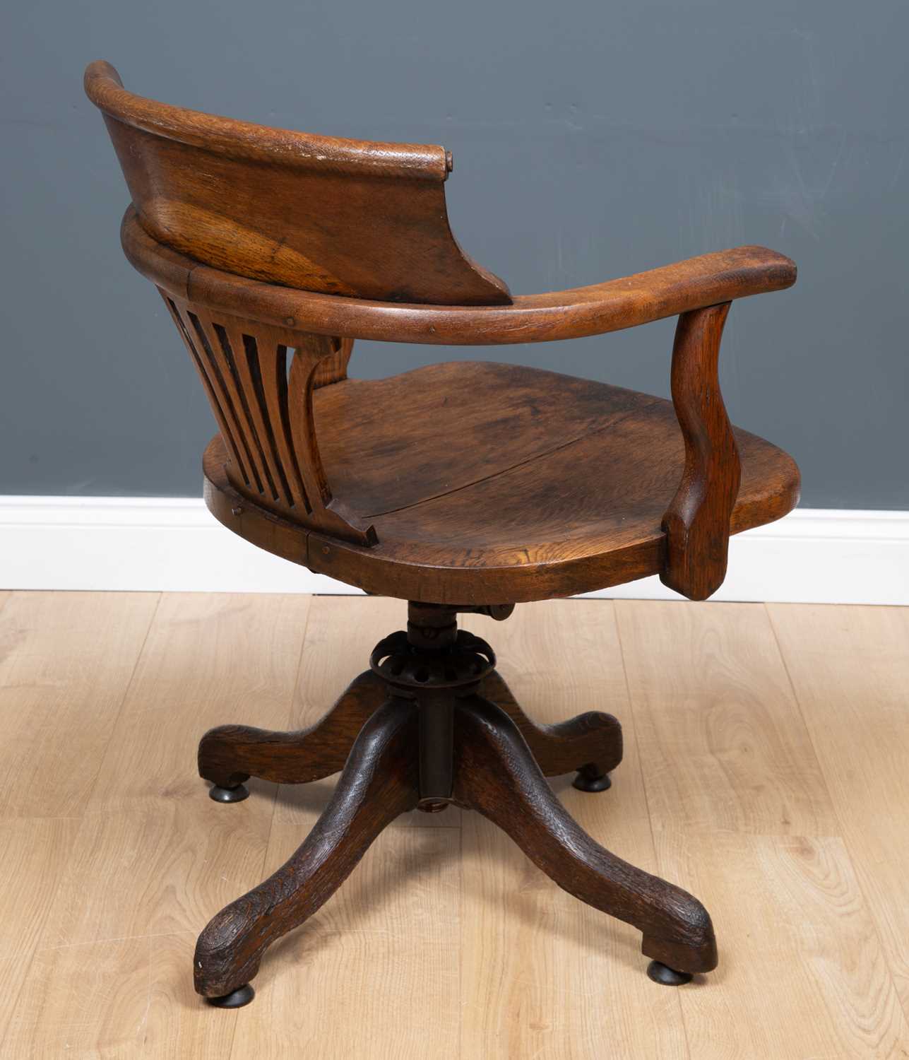 An Edwardian oak swivel desk chair with open arms on outswept supports, 58cm wide x 52cm deep. - Image 3 of 3