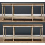 A pair of breakfront console tables with oak tops and painted bases, the turned flued legs united by
