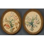 A pair of Georgian silk embroidered pictures each depicting a posy of flowers, mounted in an oval