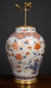 An antique porcelain large baluster jar converted to a table lamp, in imari colors, the white ground