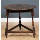 An antique oak circular cricket table with a triangular base, stamped with initials 'WH' 70cm