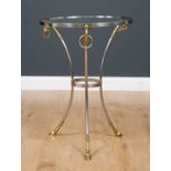 An empire style circular glass topped side table on a steel and brass tripod stand, the feet