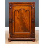 A Victorian mahogany cupboard with pilaster ornaments to either side of the panelled cupboard