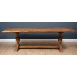 A large oak refectory table, with cleated ends and H-framed stretcher on cup and cover supports,