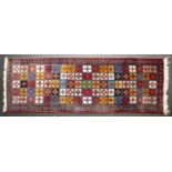 A last 20th / early 21st century woollen Runner with banded border and multiple polychrome square