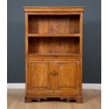 A French provincial elm cupboard with open shelves above twin panelled doors and on bracket feet,