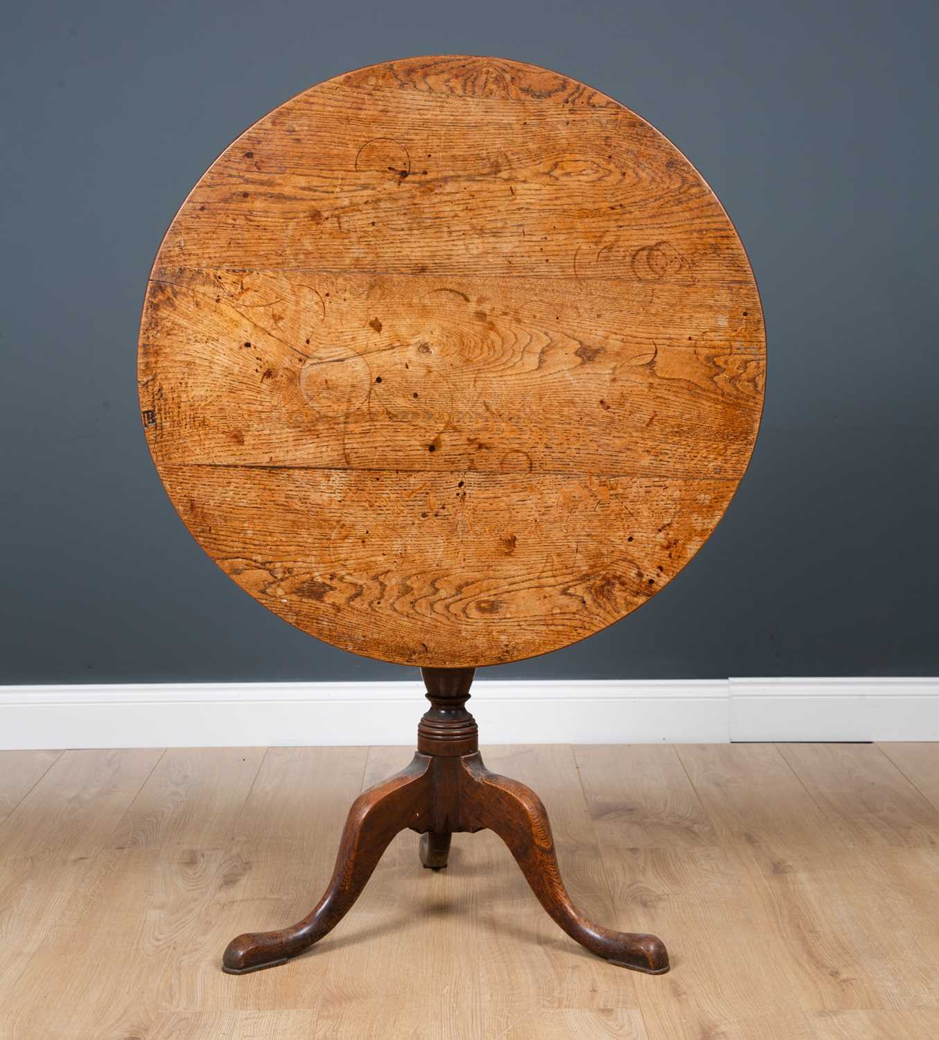 A George III oak circular tilt top tripod table with turned column support, 82cm diameter x 71.5cm