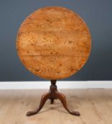 A George III oak circular tilt top tripod table with turned column support, 82cm diameter x 71.5cm