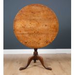 A George III oak circular tilt top tripod table with turned column support, 82cm diameter x 71.5cm