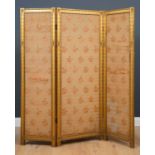 A small Victorian gilt three fold screen with floral upholstery, 114cm wide fully extended x 146cm