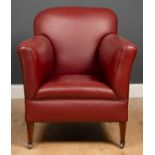 A small sized red leather upholstered armchair with square tapering front legs and casters, 69cm