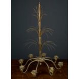 A brass eight branch chandelier, with three layers of fountain burst decoration on a central column,